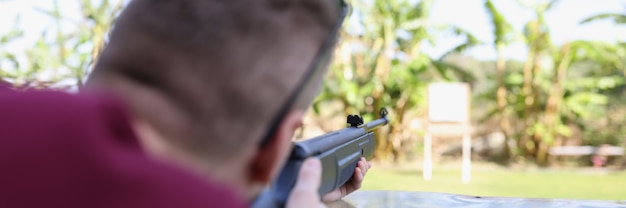 L'uomo spara un'arma al bersaglio nel poligono di tiro di strada