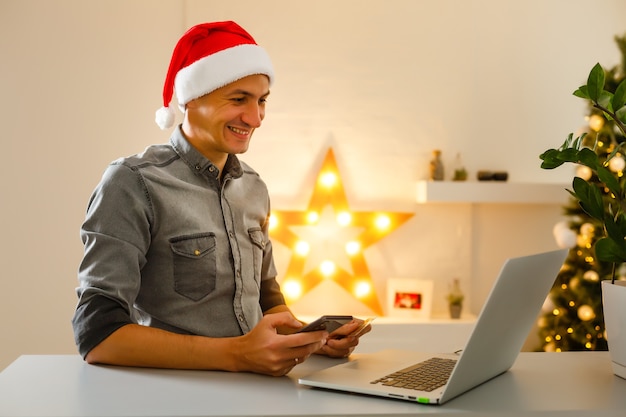 Мужчина покупает рождественские подарки онлайн