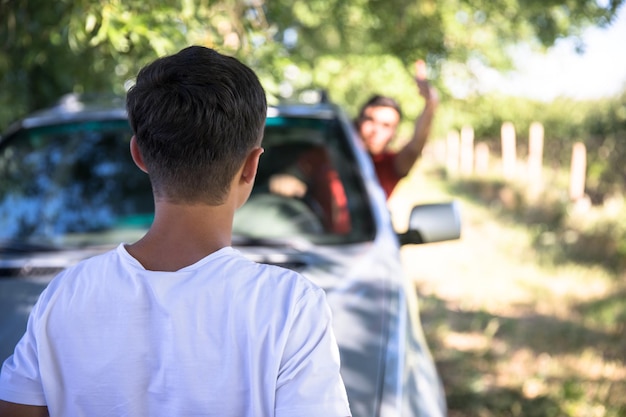 男は車の中で男に向かって叫ぶ