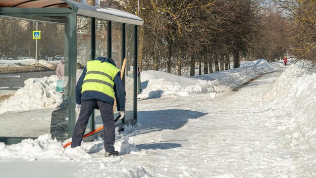 男が歩道の雪かきをしている。