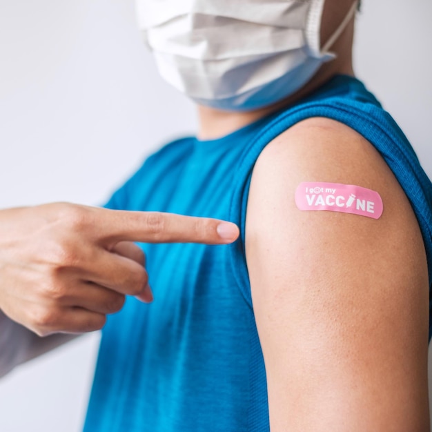 Man showing bandage after receiving covid 19 vaccine. Vaccination, herd immunity, side effect, booster dose, vaccine passport and Coronavirus pandemic