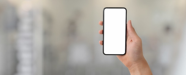 Photo a man showing blank screen smartphone in blurred glass partition office