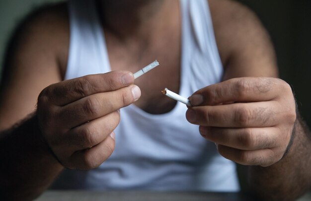 Photo man showing broken cigarette quit smoking concept