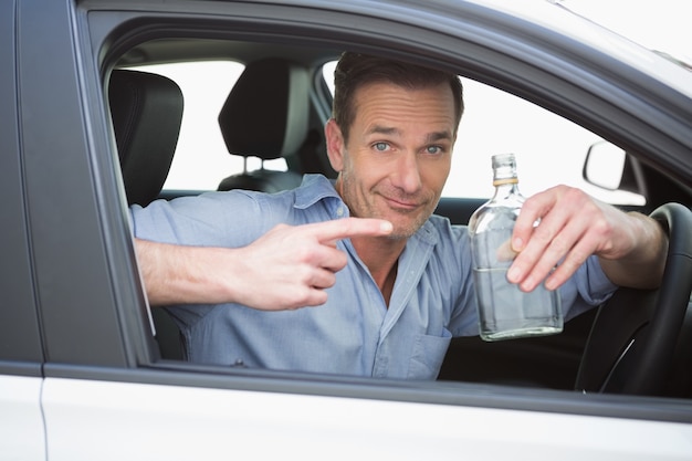 Man showing an empty bottle of vodka