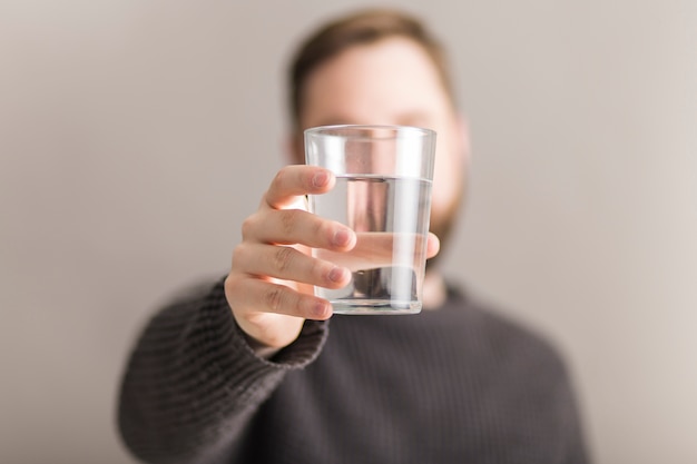 写真 水のガラスを示す男