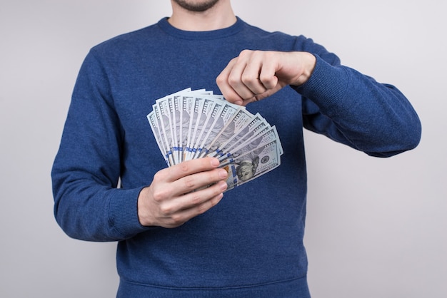 Man showing pile of money isolated grey background