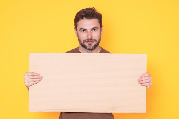 Man showing promo blank board on studio background blank signboard with copyspace advertisement