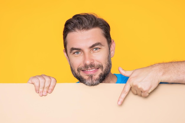 Man showing promo holding pointing finger on blank board on studio background blank signboard with c