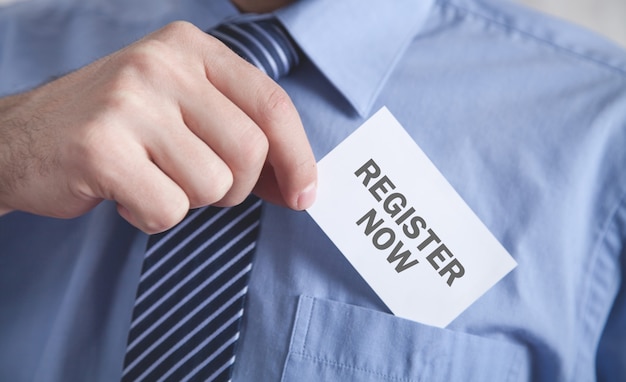 Man showing Register Now text in business card.