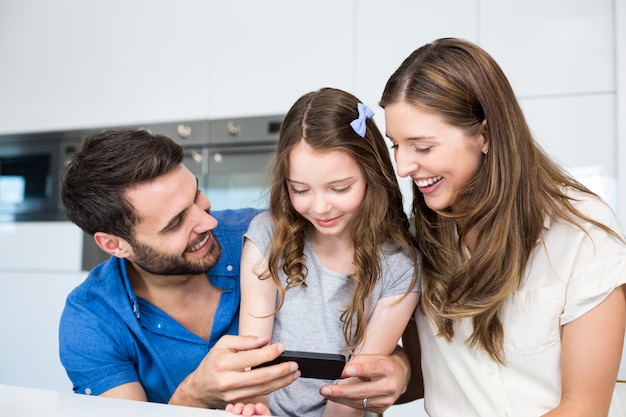 Photo man showing smart phone to family