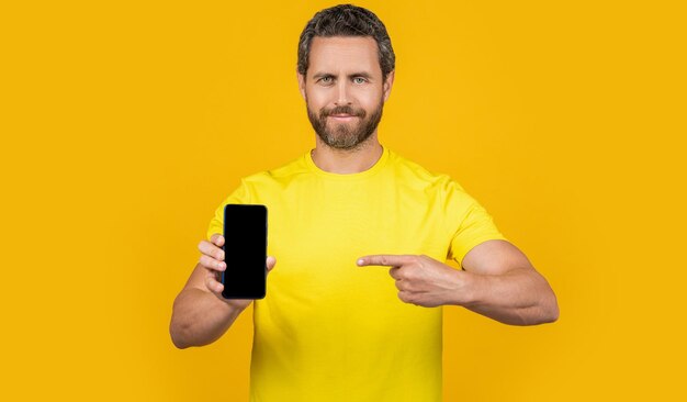 Man showing smartphone app on background pointing man showing smartphone app in studio