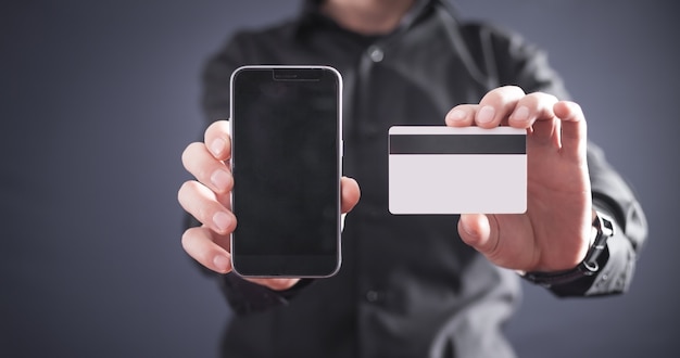 Man showing smartphone and credit card.