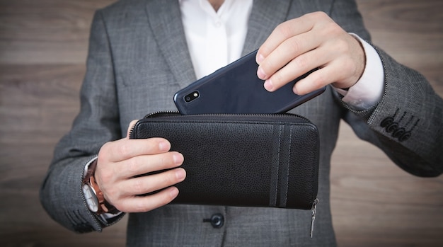 Man showing smartphone and wallet.