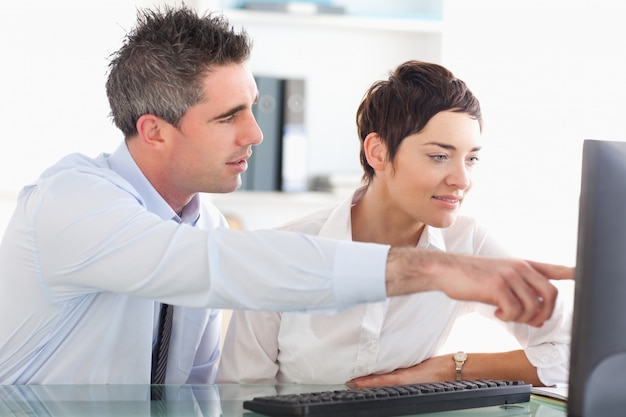 Man showing something to his coworker on a computer