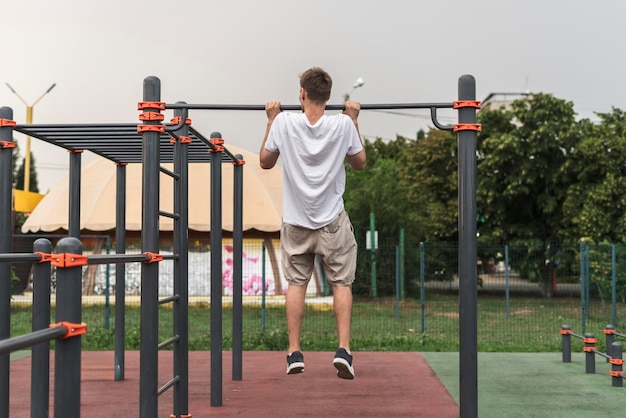 A man showing strength and agility with impressive pullups in a serene park setting