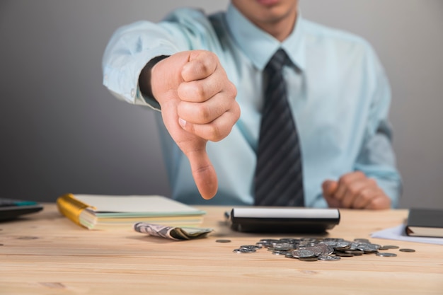 Man showing thumb down at his desk