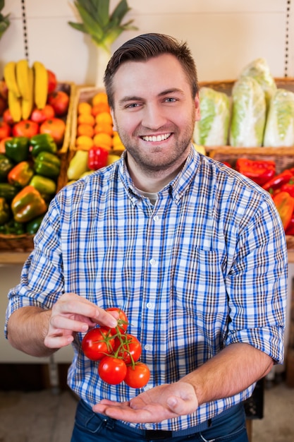 Man showing tomato branch.