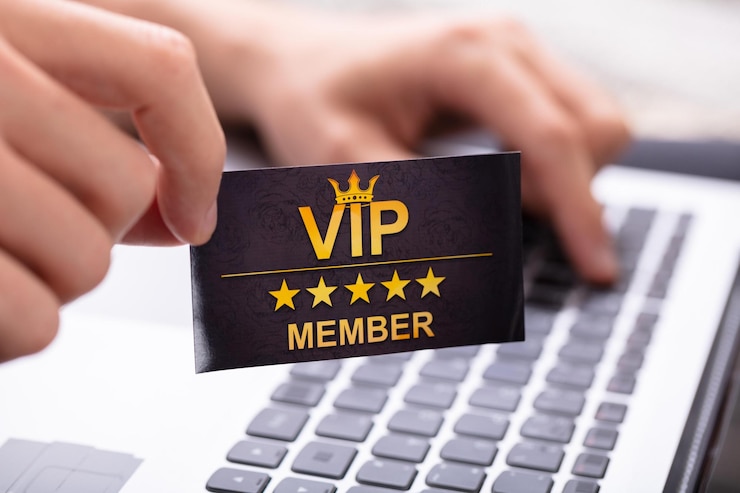 Фотография мужчина показывает карту vip-члена во время использования ноутбука
