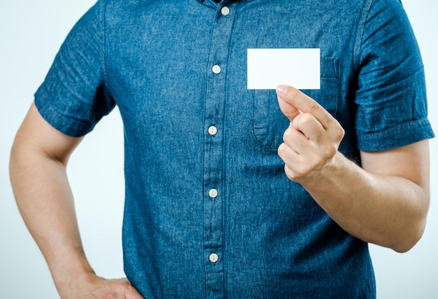 Мужчина показывает белую пустую визитку на изолированном фоне. Сосредоточьтесь на карточке.