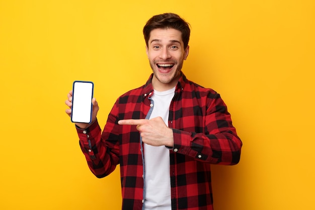 Man showing white empty smartphone screen and pointing finger