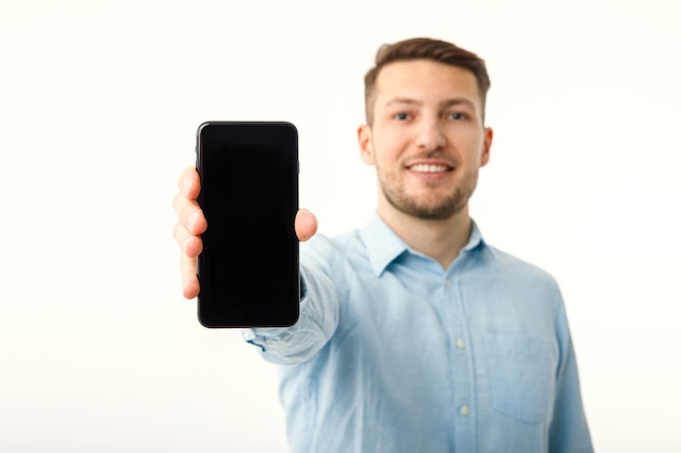 The man shows on the copyspace screen of the smartphone Isolated on a white background