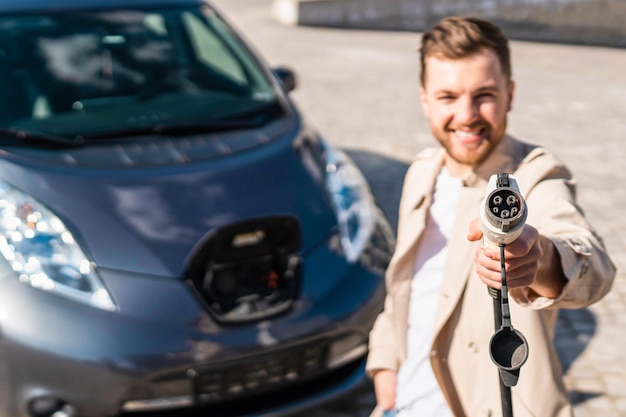 Man shows plug for charging electric cars into the camera