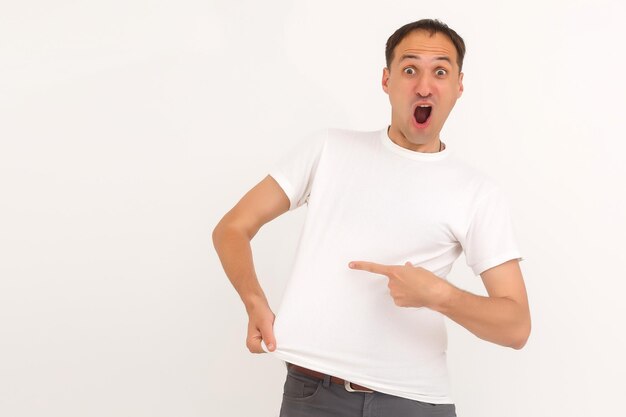 man shows a stain on his white t-shirt