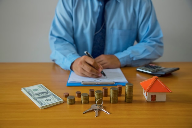 Photo man signing paperwork, new home in background