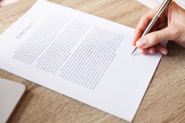 Photo man signs a contract at a desk in a company office