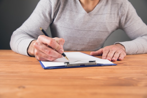 A man signs on a document