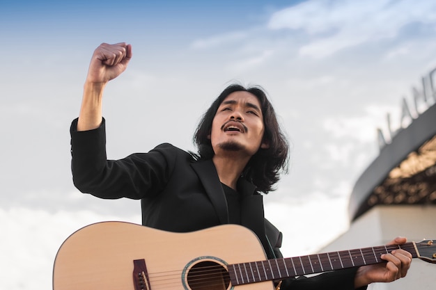 Man sing song and playing guitar outdoor