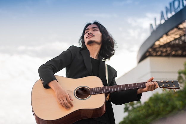 L'uomo canta una canzone e suona la chitarra all'aperto