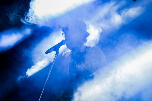 Foto uomo che canta in mezzo al fumo al concerto