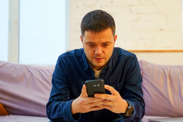 Man sit on the couch and using smartphone