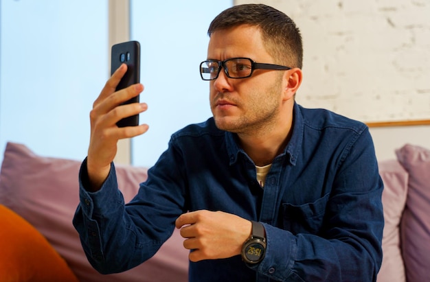 Man sit on the couch and using smartphone