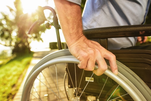 L'uomo si siede in sedia a rotelle. assistenza per disabili.