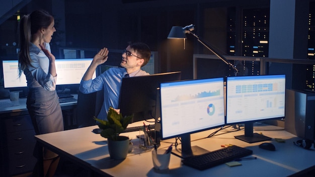 A man sits at a desk in front of two computer monitors, one of which says'data analytics '