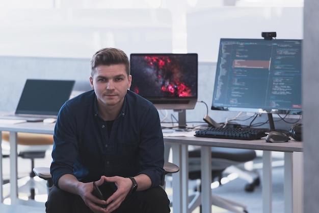 a man sits in front of a computer with a fire on it