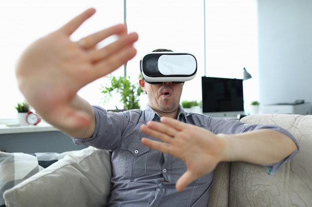 Man sits at home on the couch uses virtual reality