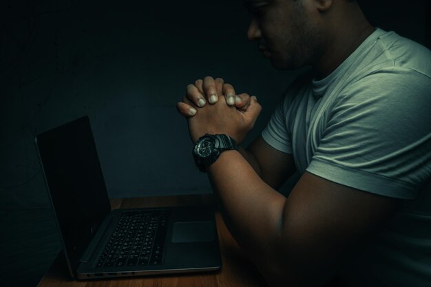 Photo a man sits on a laptop in a dark room concept is addicted to the internet