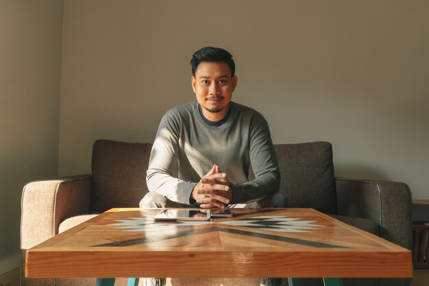 Man sits on the sofa in his living room, feeling relax in the morning.