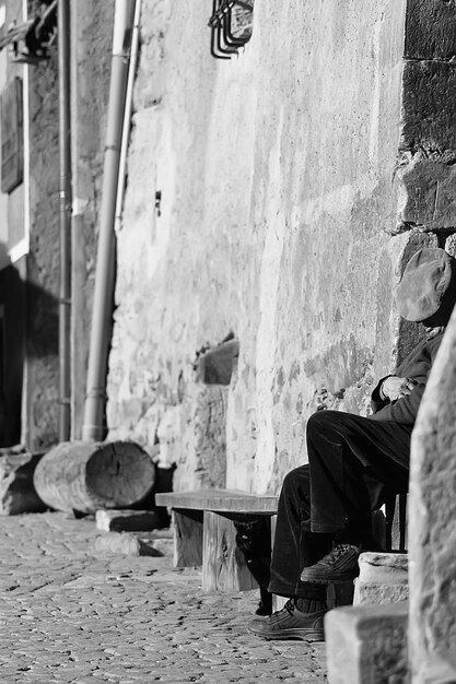 Фото Человек сидит у стены здания в солнечный день