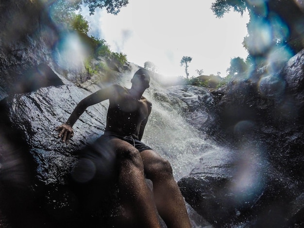 Фото Человек, сидящий у водопада.