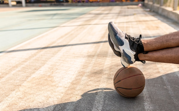 Photo man sitting next to a basketball