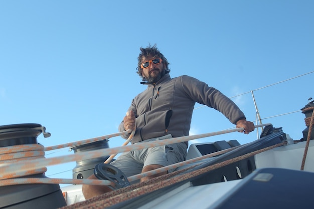 Photo man sitting in boat against clear blue sky