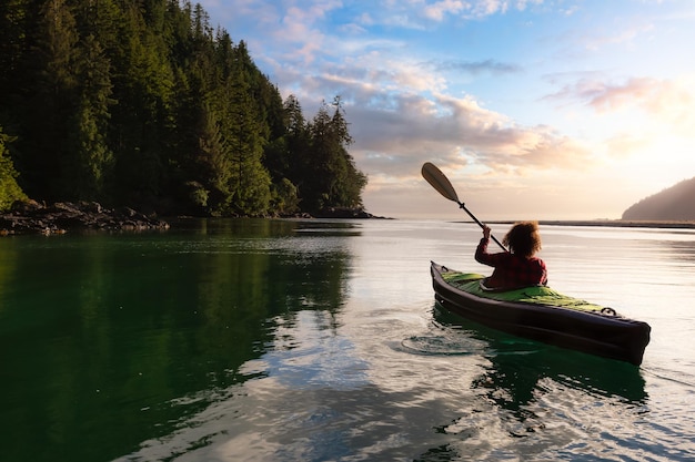 man sitting on boat in lake against sky