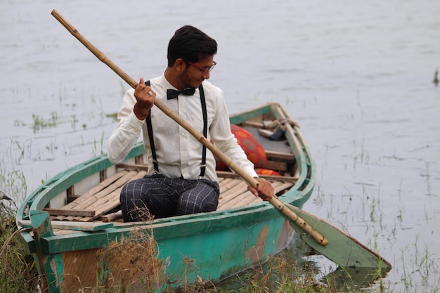 Photo man sitting in boat on lake