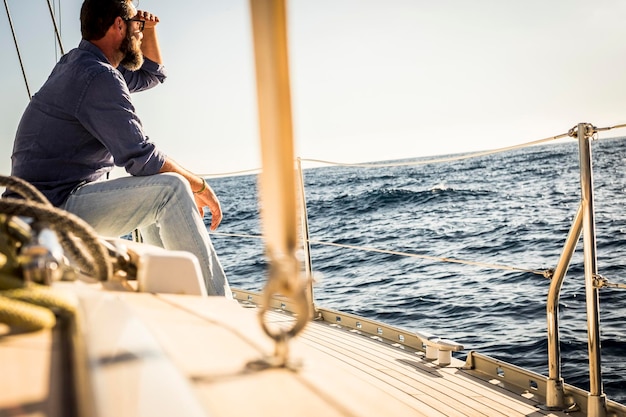man sitting on boat sailing in sea against sky
