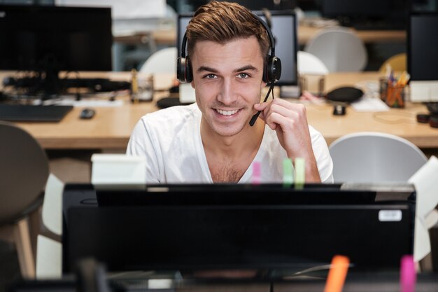 Man sitting by the computer in headphone