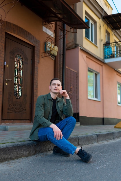 Photo a man sitting by the door having lost the keys to his house